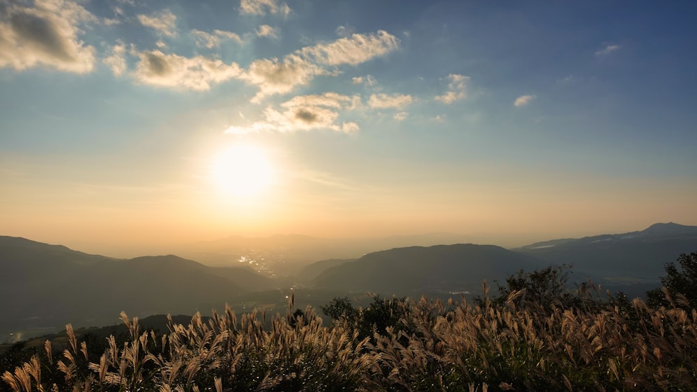 the sun is setting over a mountain range