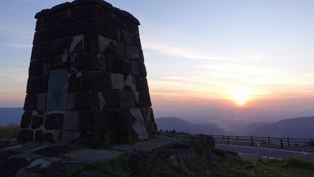 una torre di pietra che si trova in cima a una collina verde lussureggiante