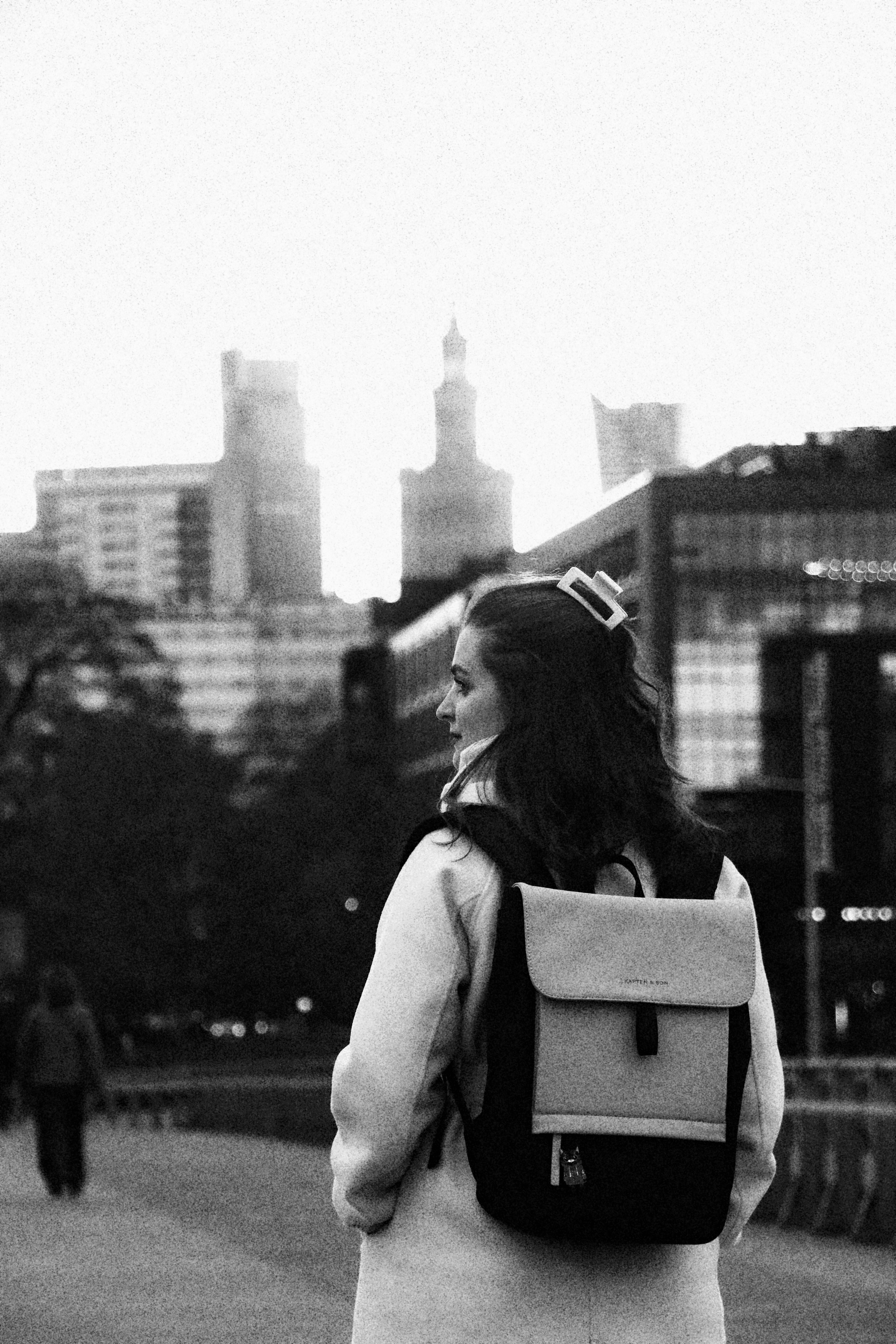 a woman walking down a street with a backpack on her back
