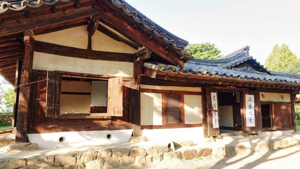 a small building with wooden shutters and windows