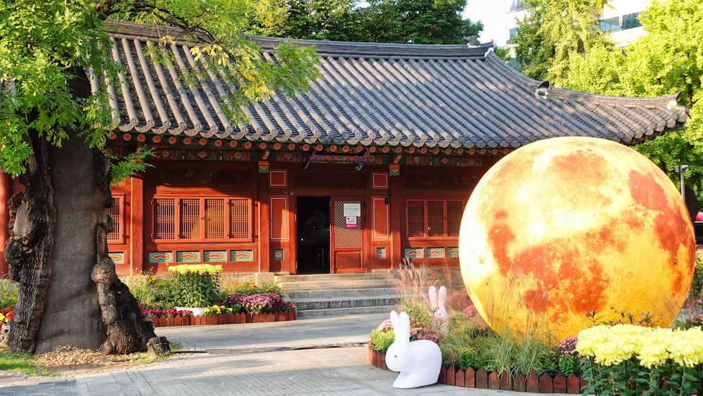 a large orange ball sitting in front of a building