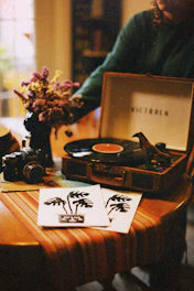 A cozy studio space with vinyl records and mixing equipment bathed in warm light.