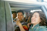 Group of happy students waving from inside the school bus windows.