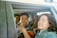 A lively group of friends laughing inside a sleek party bus adorned with colorful lights.