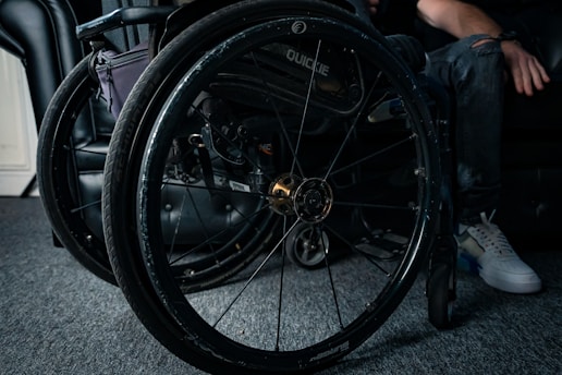 Electric wheelchair being repaired by a technician at a residential home.
