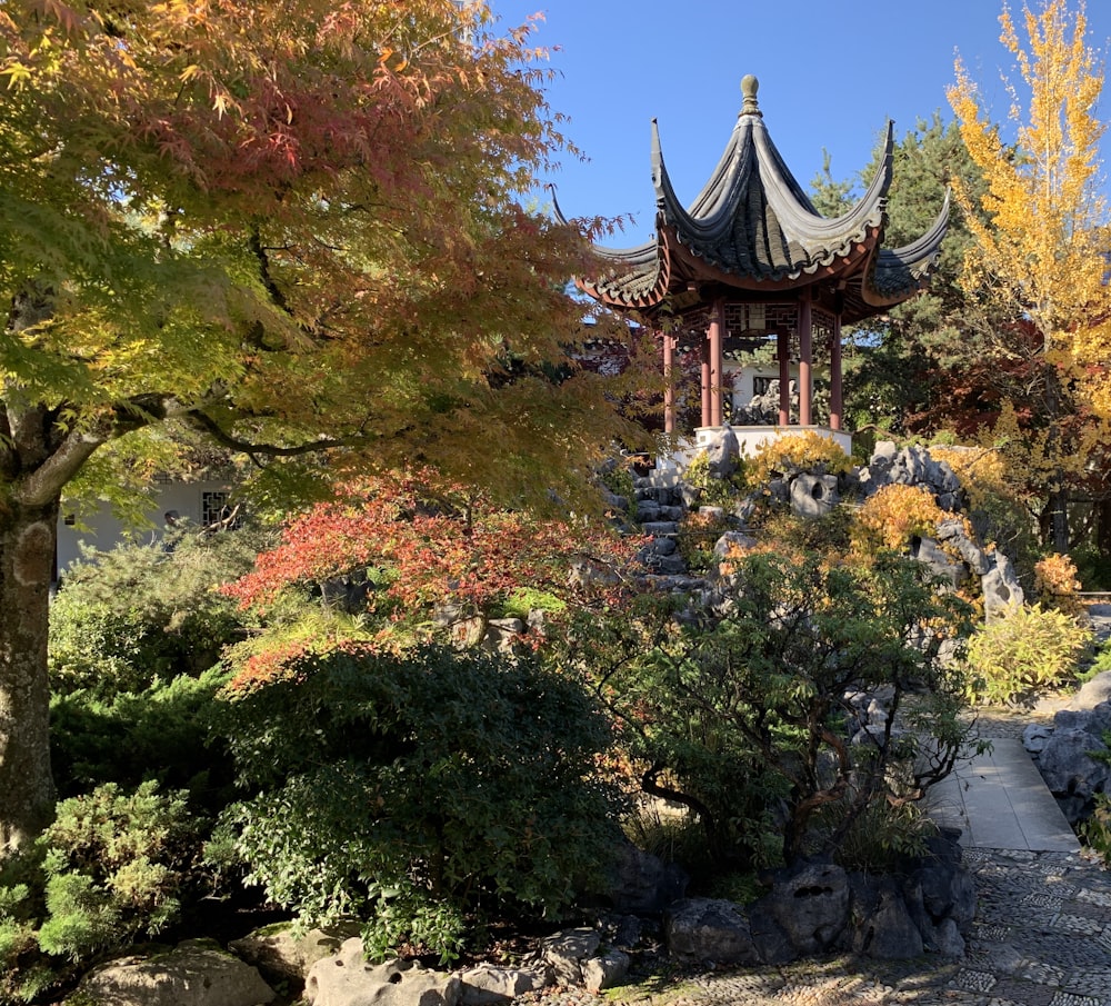 a gazebo surrounded by trees and rocks in a park