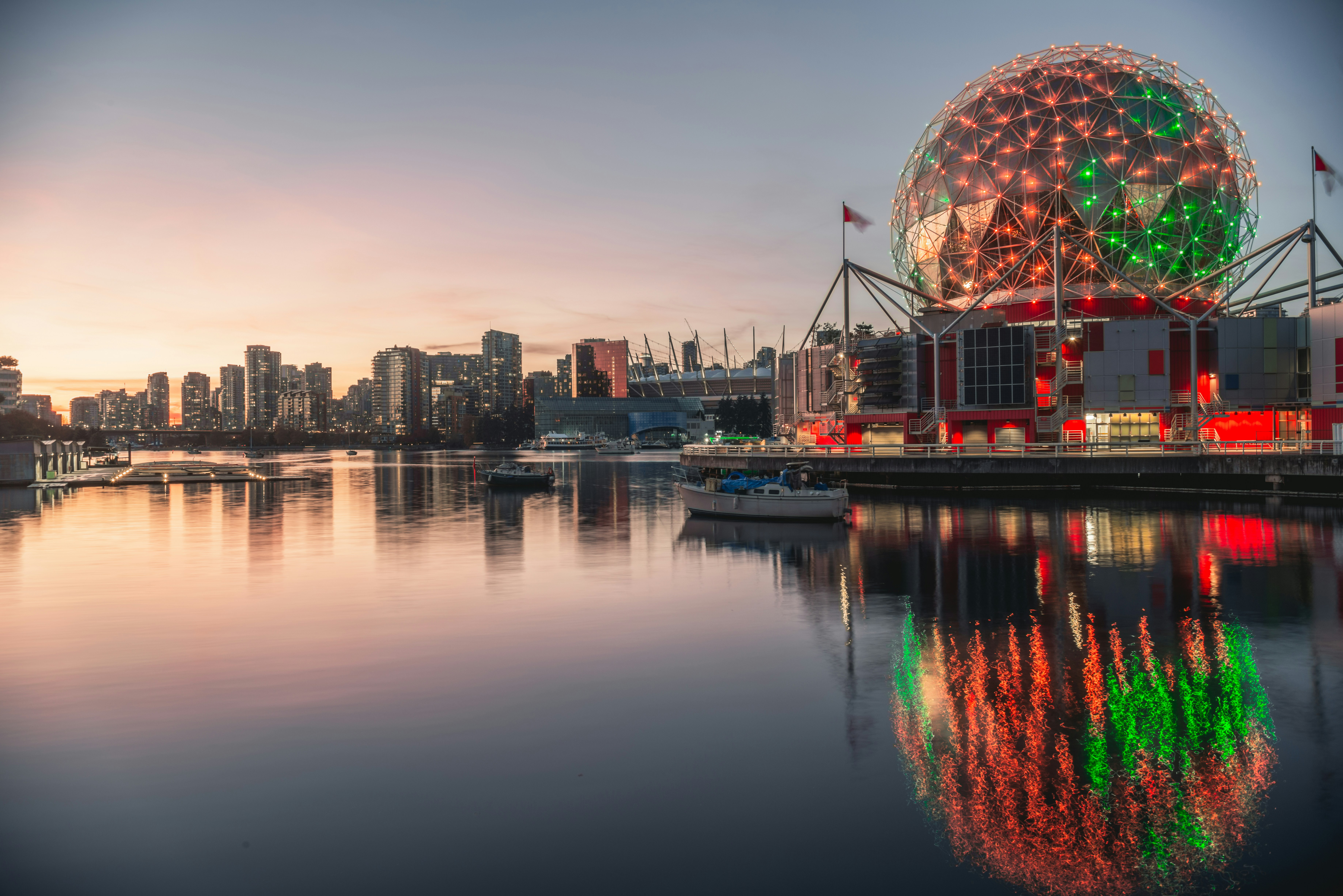 a large building with a christmas tree on top of it, Science World during Halloween, with the sunset in the background