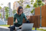 A remote worker video conferencing with colleagues from a sunny park bench.