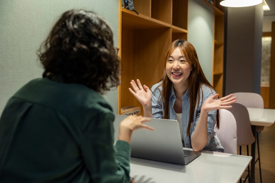Two colleagues sitting at a table having an open conversation, representing a transparent manager-employee discussion.