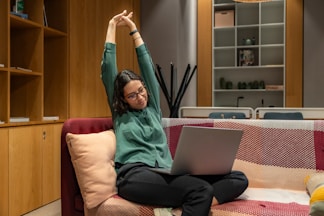 a woman sitting on a couch using a laptop