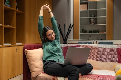 a woman sitting on a couch using a laptop