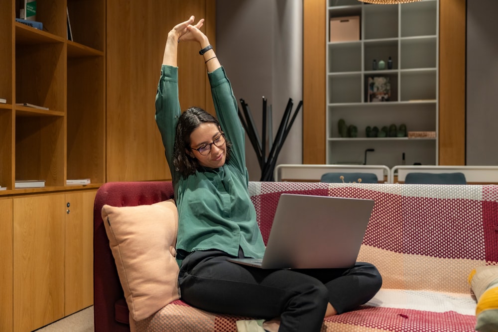 a woman sitting on a couch using a laptop