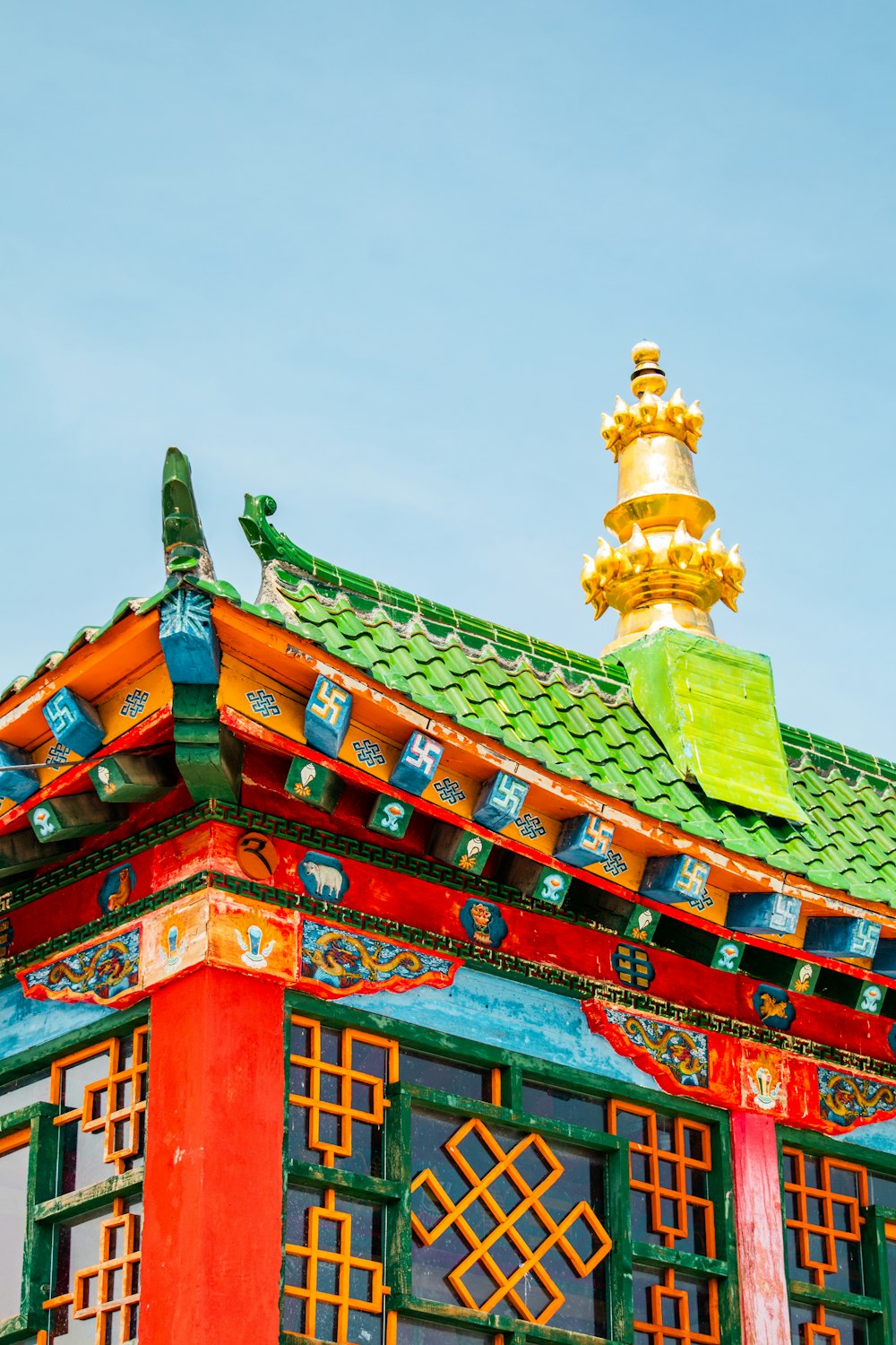 a colorful building with a gold top and a green roof