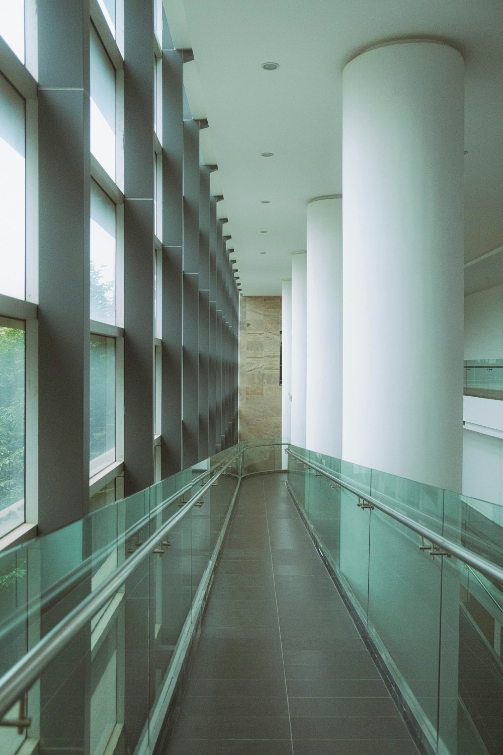 a long hallway with glass railings and windows