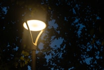 Close-up of LED streetlight glowing warmly at dusk.
