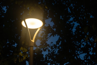 Close-up of a solar-powered garden light glowing warmly at dusk