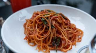 A vibrant plate of spaghetti with rich tomato sauce and fresh basil leaves.