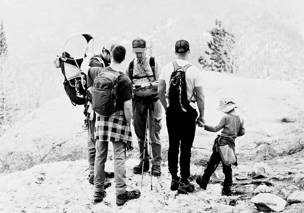 a group of people standing on top of a snow covered mountain