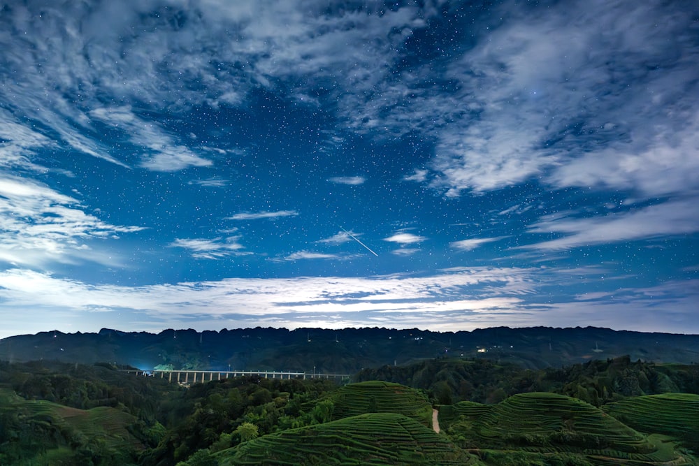 Une vue panoramique sur une colline verdoyante sous un ciel bleu