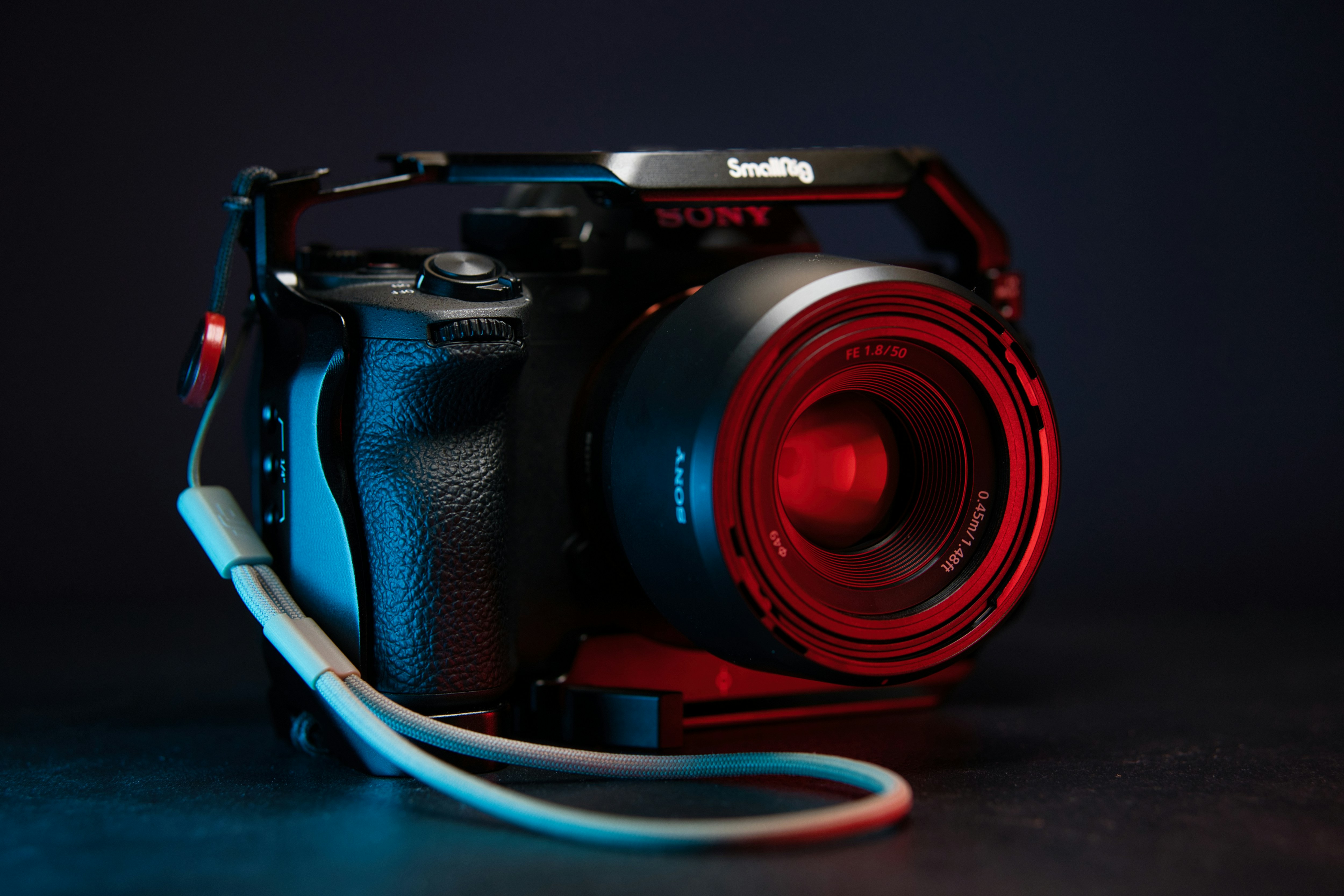A camera with a red lens on a black background photo – Free Strap Image ...