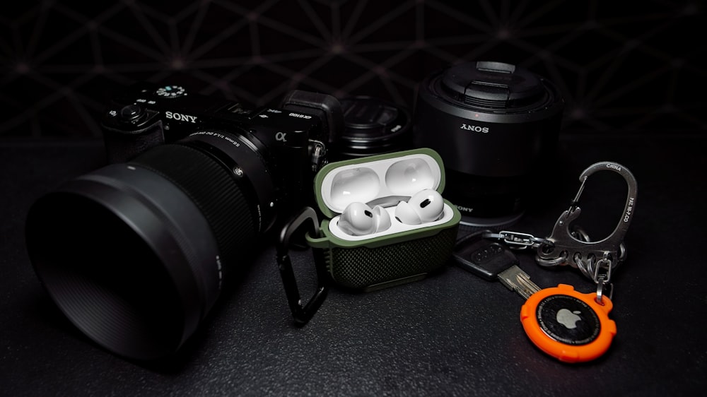 a camera with a case and a pair of ear buds