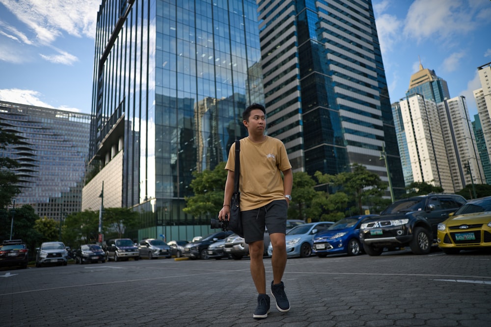 a man walking down a street in front of tall buildings