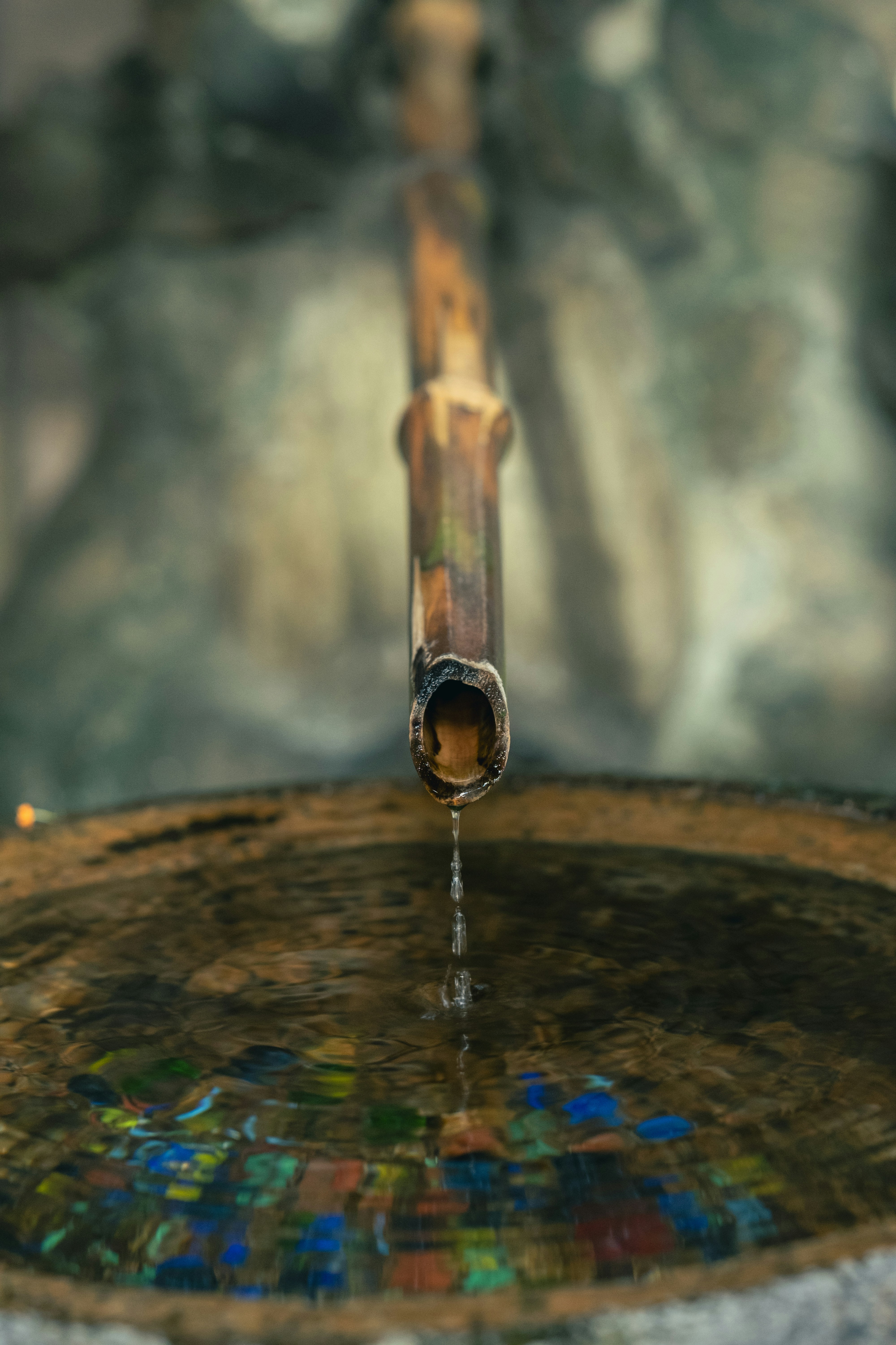 a water fountain with a metal spigot pouring out of it