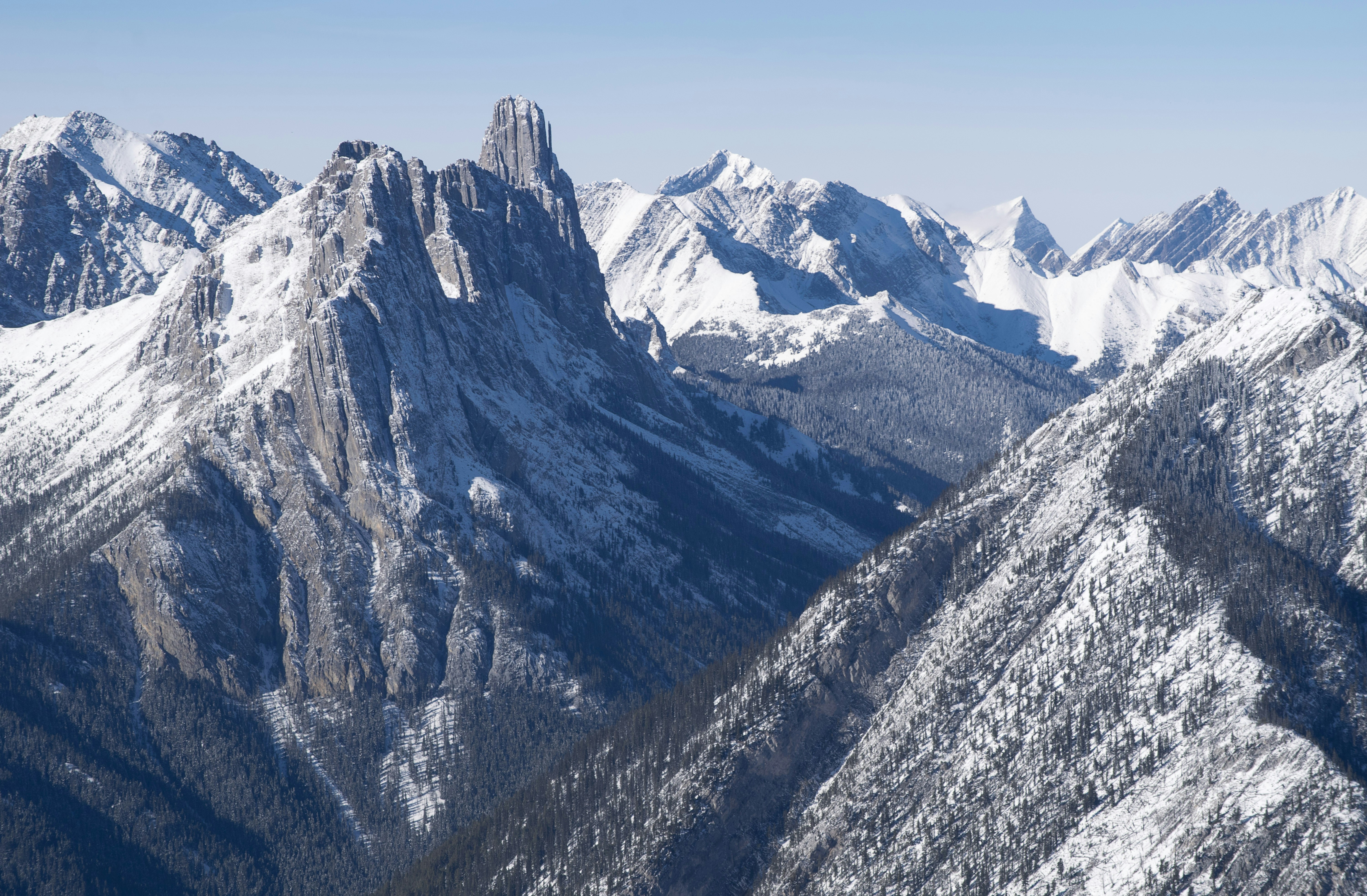 a mountain range covered in snow with mountains in the background