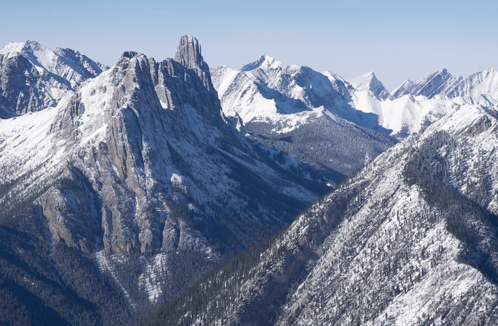 a mountain range covered in snow with mountains in the background