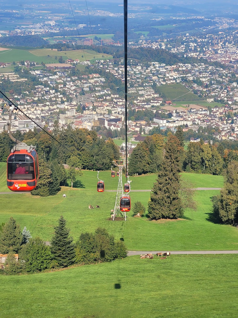 a cable car going over a lush green hillside