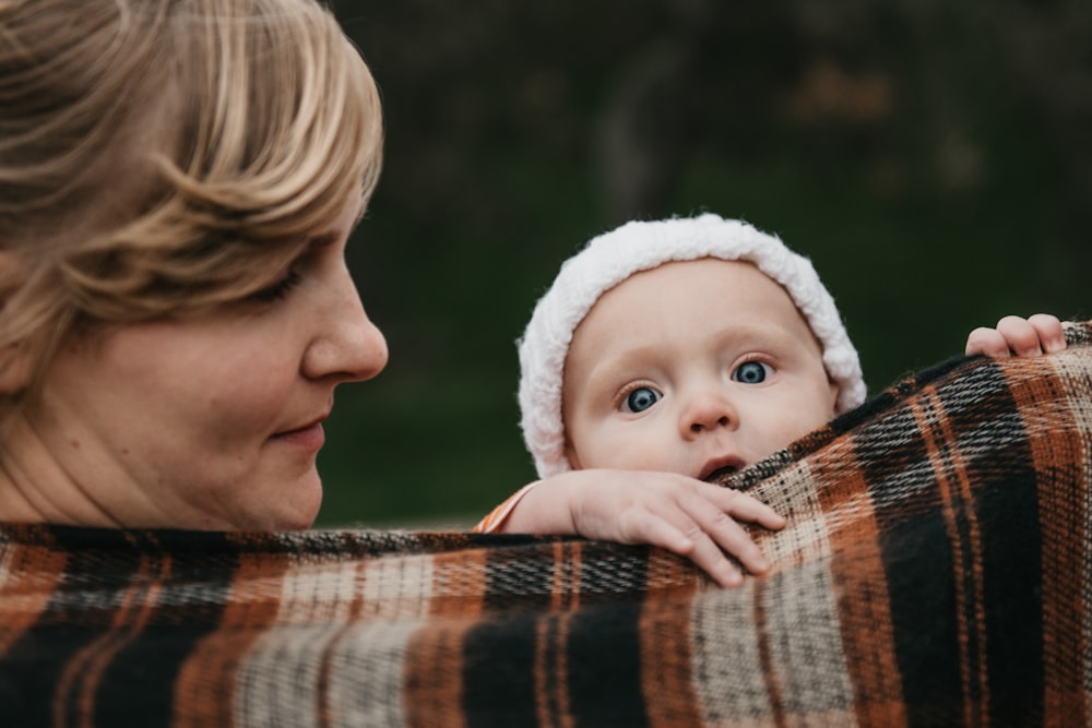 a woman holding a baby wrapped in a blanket