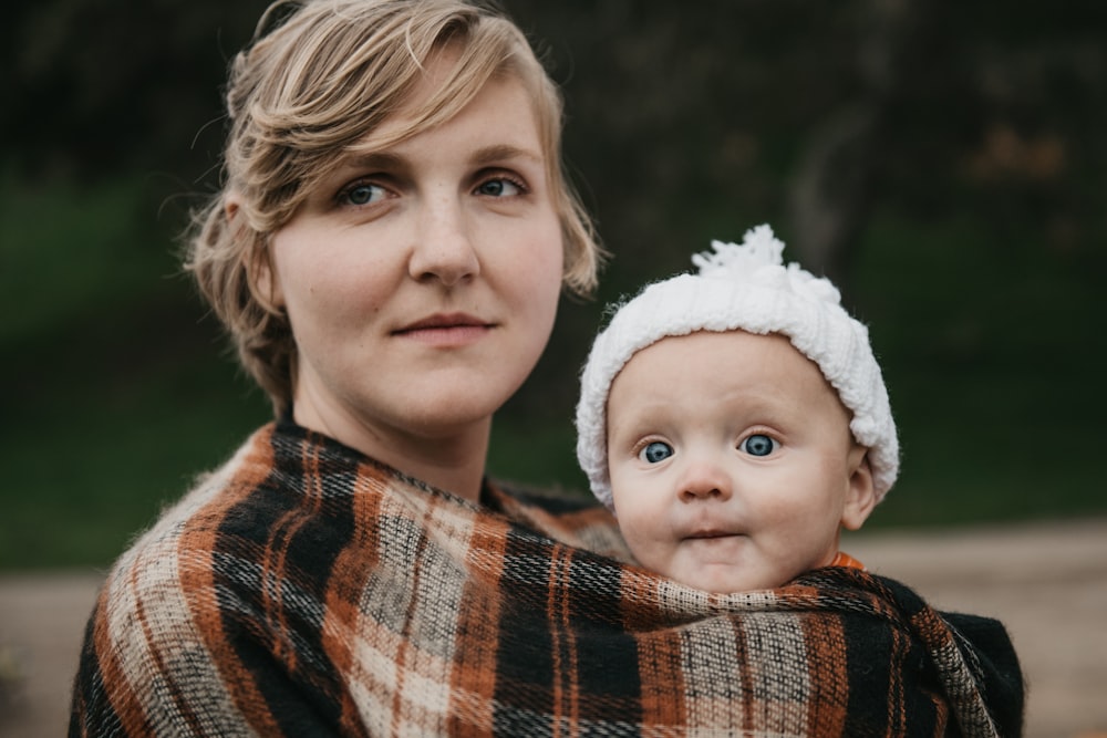 a woman holding a baby wrapped in a blanket