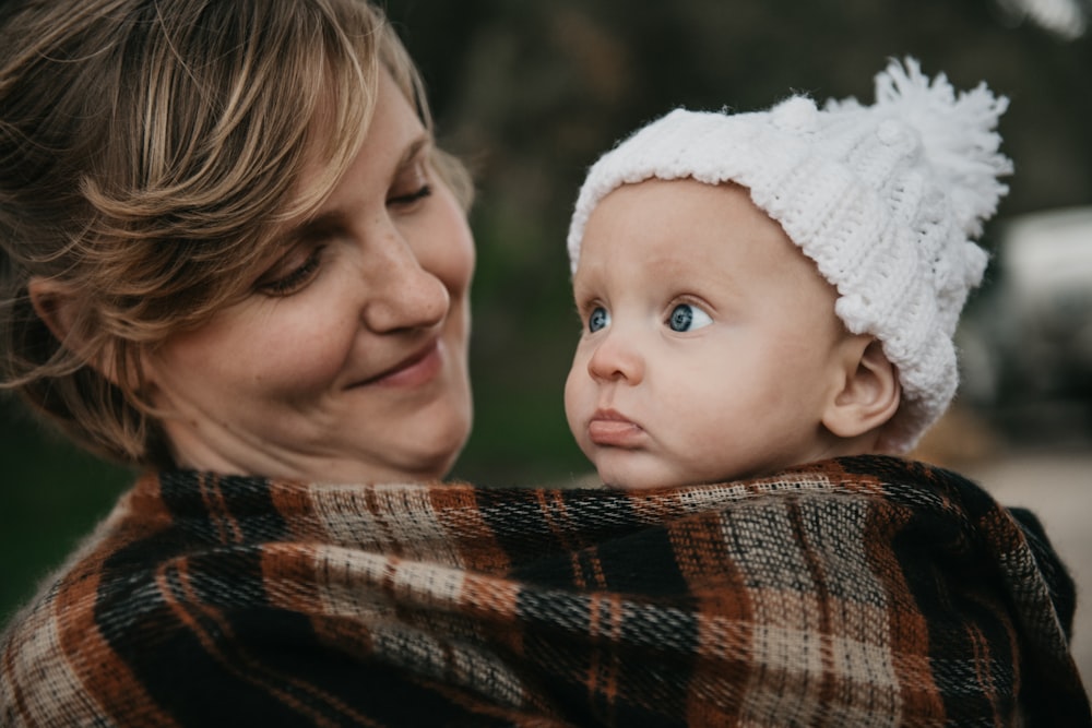 a woman holding a baby wrapped in a blanket