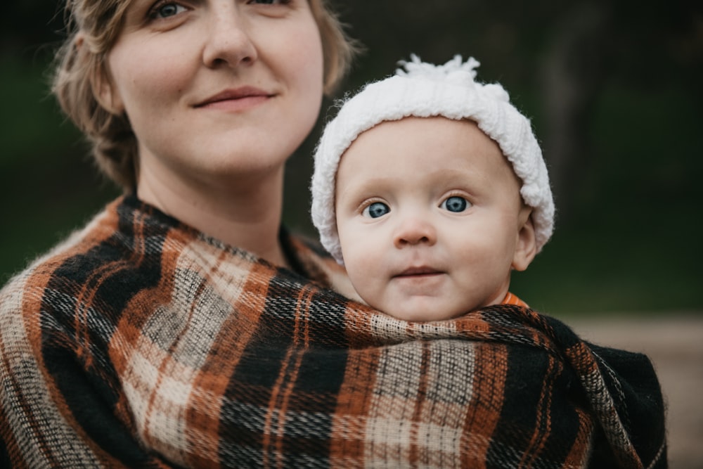 a woman holding a baby wrapped in a blanket