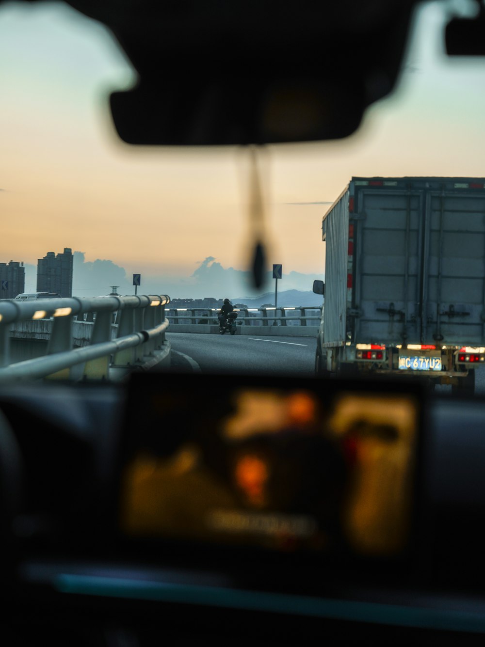 a truck driving down a highway next to a traffic light