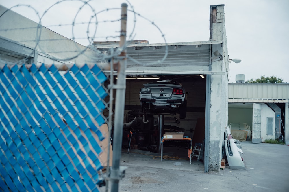 a car is parked in a garage with a fence around it