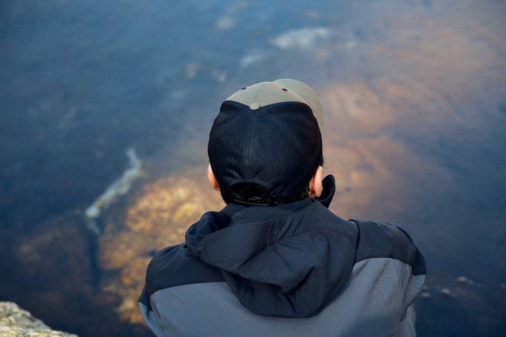 a person sitting on top of a cliff overlooking a body of water