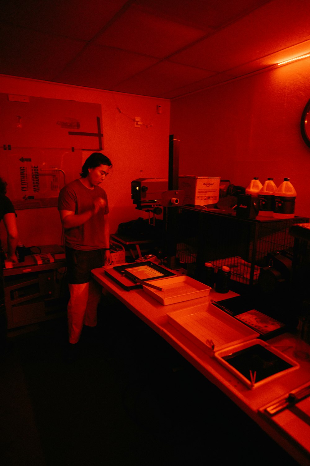 um homem em pé em uma sala com uma luz vermelha