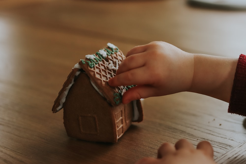 a child is decorating a gingerbread house