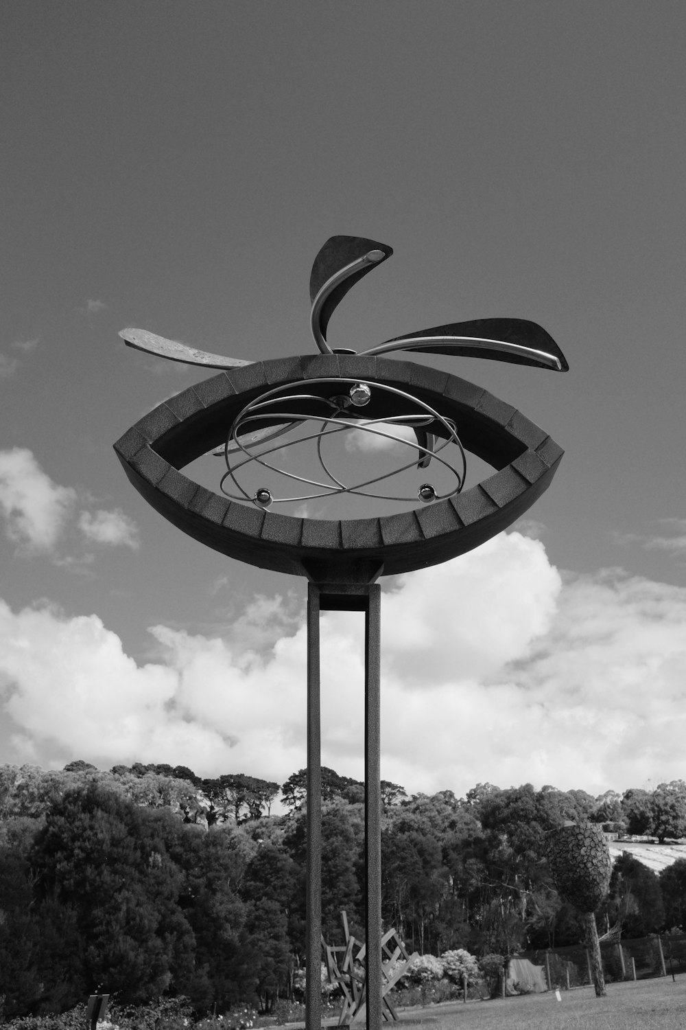 a black and white photo of a sculpture in a park