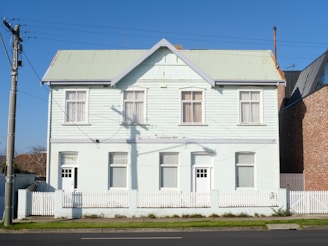 a white house with a white picket fence in front of it