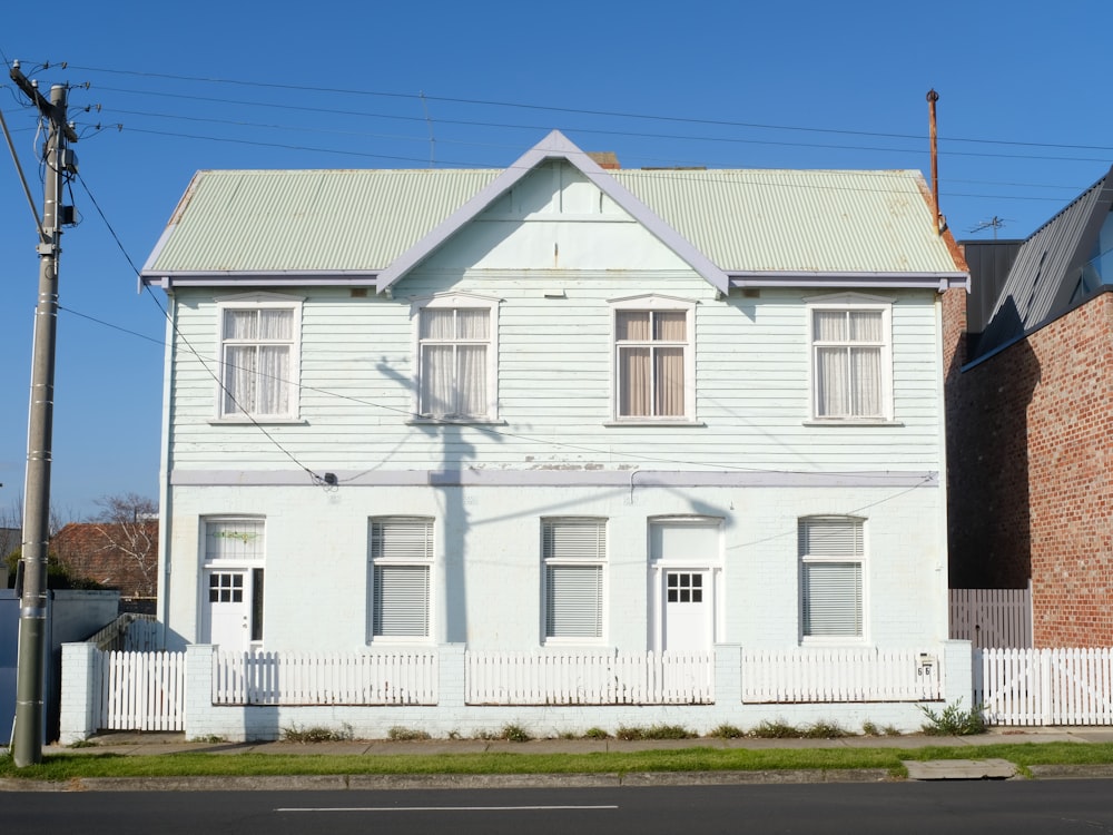 a white house with a white picket fence in front of it