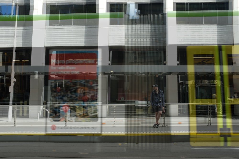 a man walking down a street past a tall building