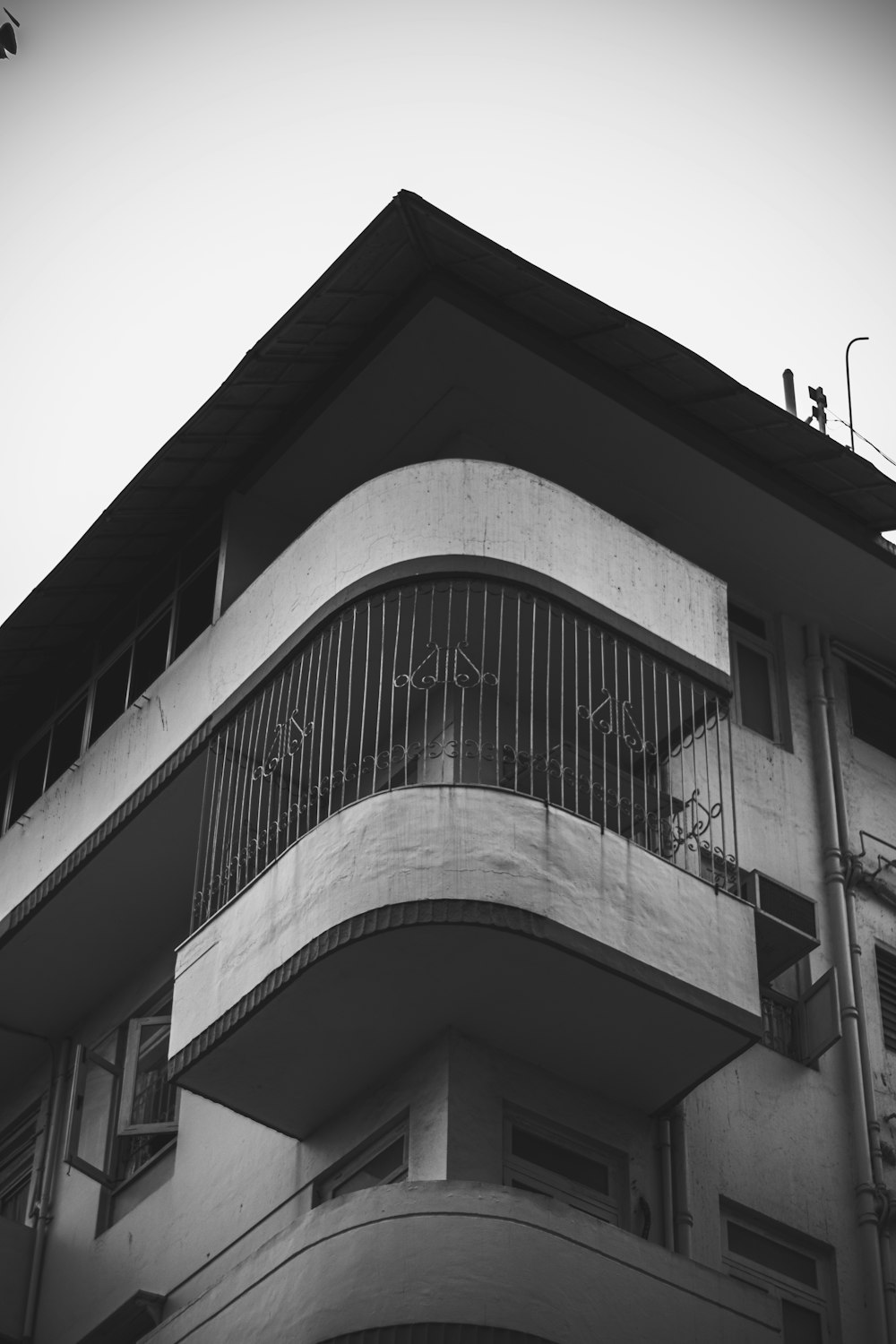 a black and white photo of a building with a balcony