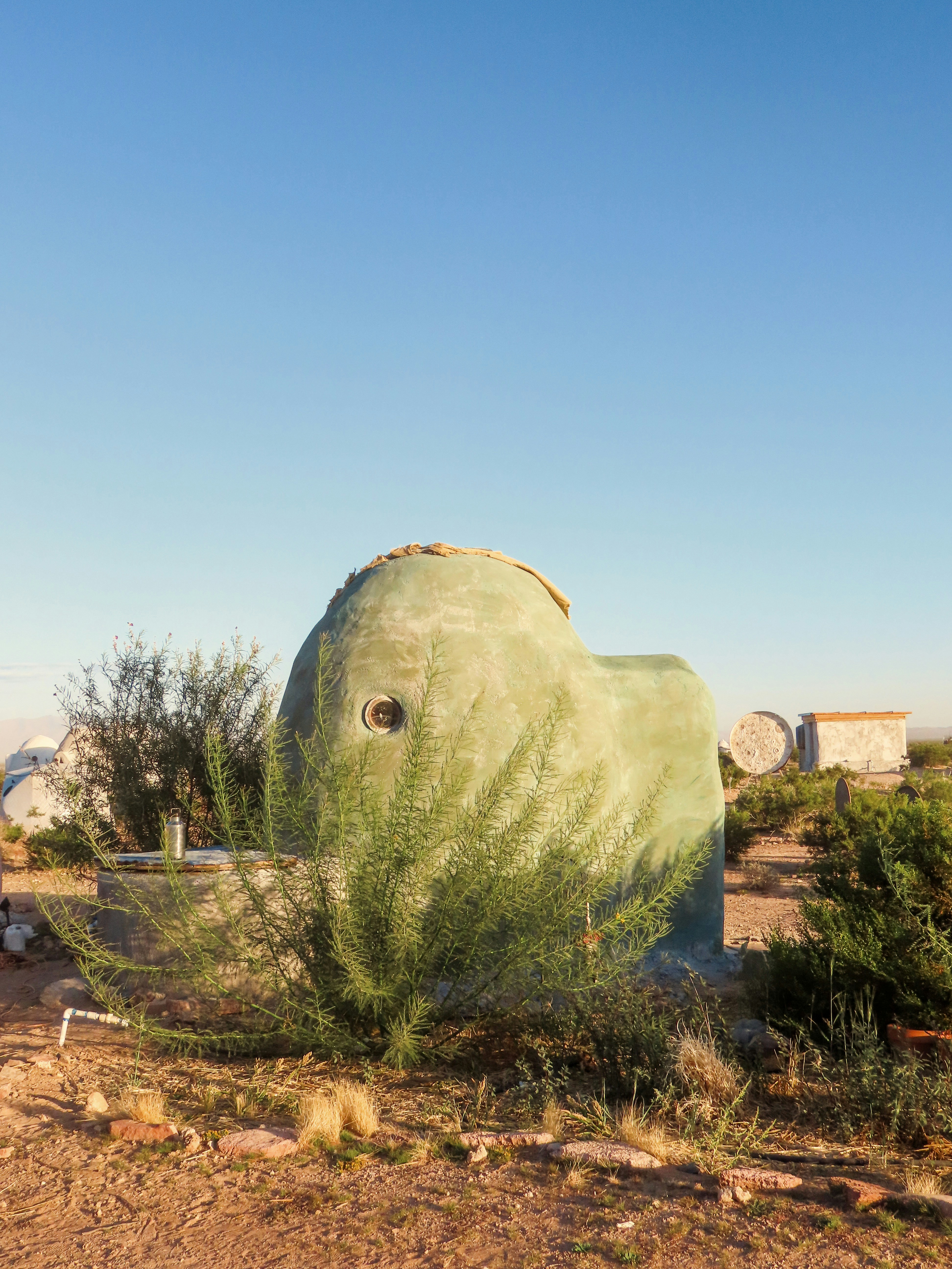 a large elephant statue in the middle of a desert