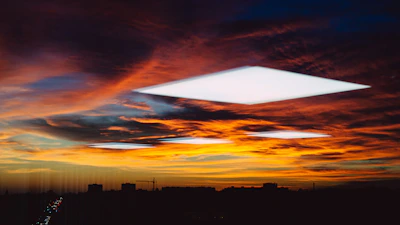 A vibrant sunset view from a balcony overlooking a cityscape, evoking reflection and creativity.