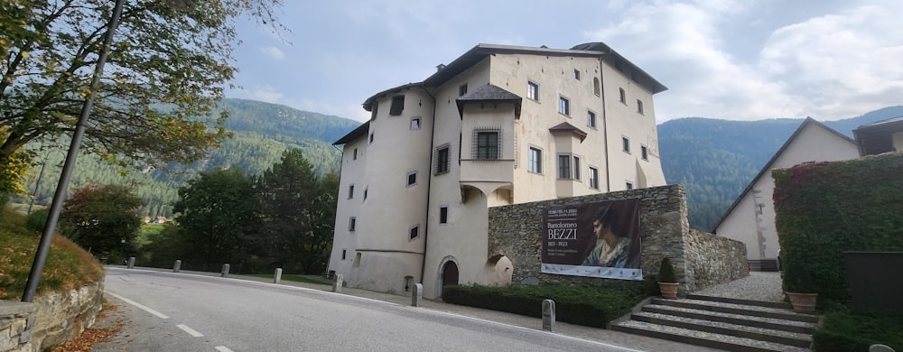 a large white building sitting on the side of a road