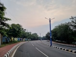 an empty street with a blue pole on the side of it