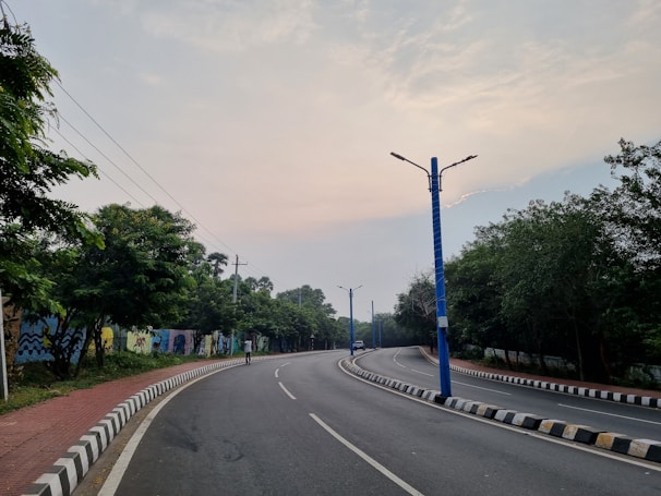 an empty street with a blue pole on the side of it