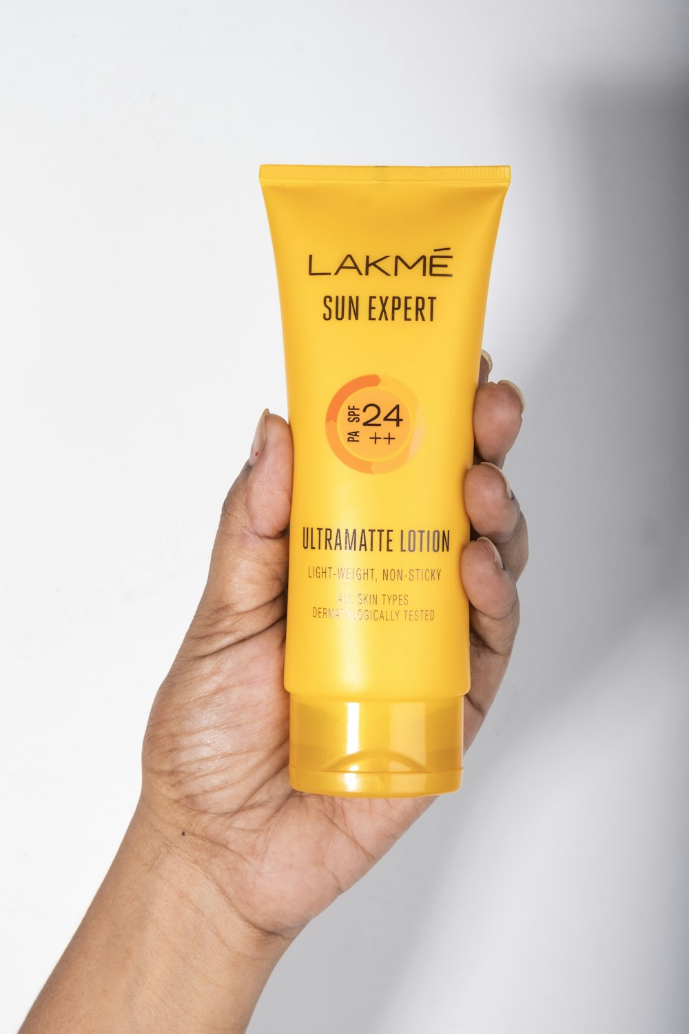 a hand holding a tube of sunscreen
